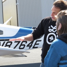 Pilot Nick Heffron shows Brady Nelson how an Aileron works during preflight